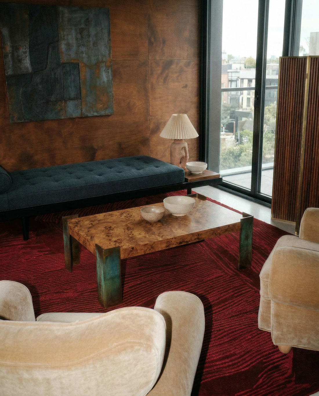 Mobilier de collection en bois et velours posé sur un tapis rouge Rugier